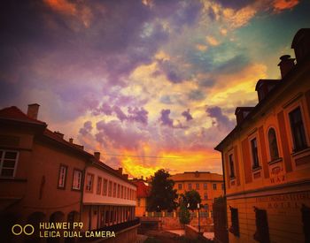 Street amidst buildings against sky during sunset