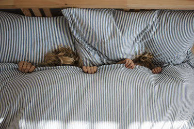 High angle view of mother with daughter lying on bed at home