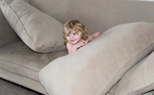 Portrait of happy boy relaxing on sofa at home