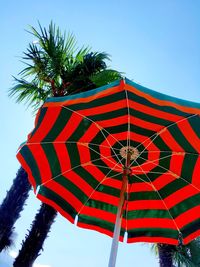 Low angle view of umbrella against clear blue sky