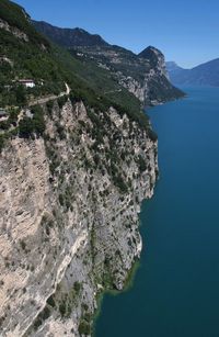 Scenic view of sea and mountains against clear blue sky