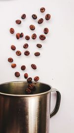 Coffee beans on table against white background