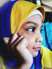 Close-up of cute girl wearing hijab looking away