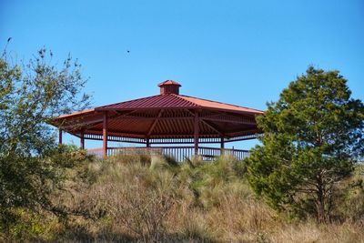 Gazebo on field against clear blue sky