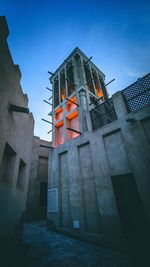 Low angle view of illuminated building against sky at dusk