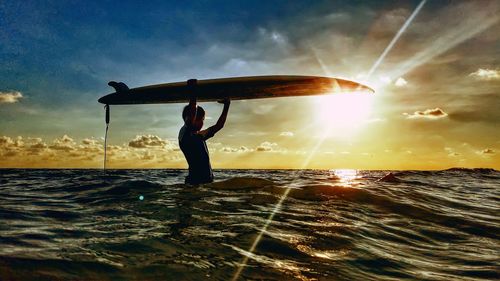 Silhouette man standing by sea against sky during sunset