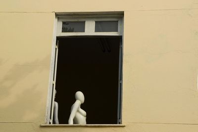Close-up of window on building with a store mannequin on it