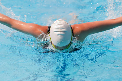 Woman wearing goggles swimming in pool