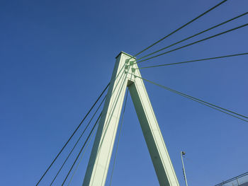 Low angle view of suspension bridge against clear blue sky