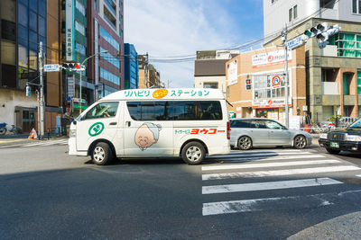 Vehicles on road by buildings in city