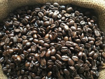 New dark brown roasted arabica coffee bean from northern of thailand in a natural brown sack