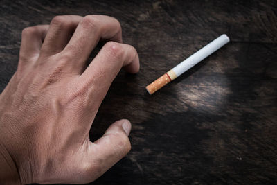 Close-up of hand holding cigarette
