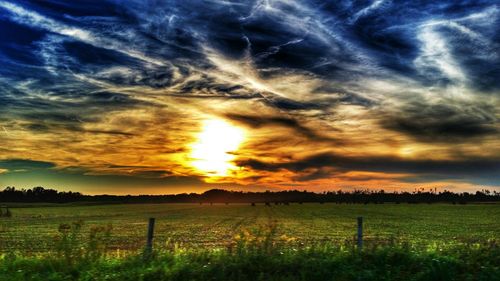 Scenic view of field against cloudy sky