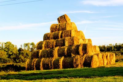 Hay bales on field against sky