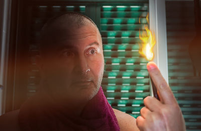 Portrait of mid adult man holding lit candles