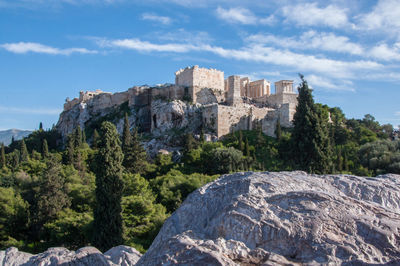 Low angle view of old fort on mountain against blue sky during sunny day