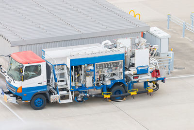 Vehicles on road by building