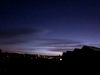 Silhouette buildings against sky at dusk