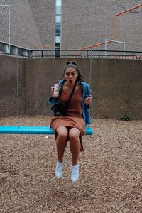 Full length portrait of young woman standing on playground