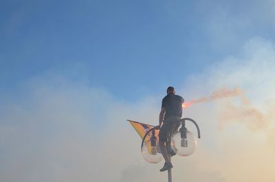 Low angle view of people against sky