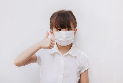 Portrait of senior woman standing against white background