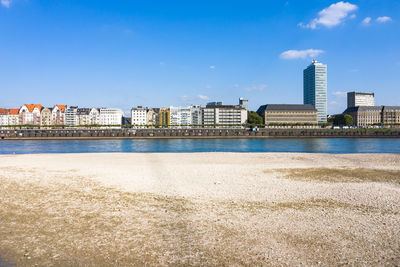 View of river by buildings against sky