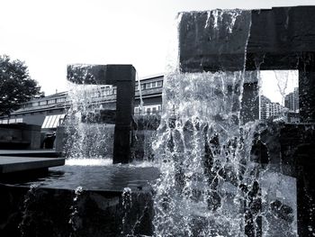 Fountain in city against clear sky