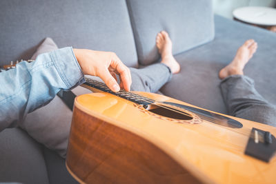 Midsection of man playing guitar