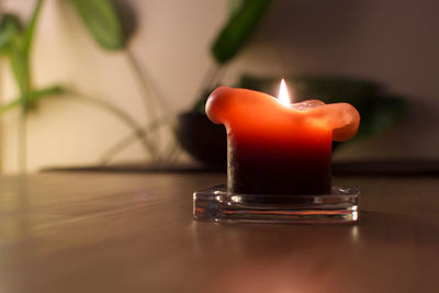 Close-up of lit candle on table
