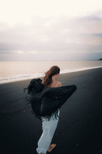 Woman looking at sea against sky