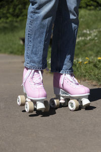 Woman skating in jeans and pink roller skates