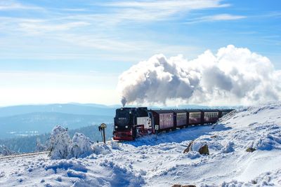 Scenic view of train against sky during winter
