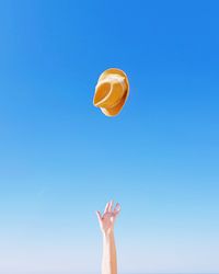 Close-up of hand against clear blue sky