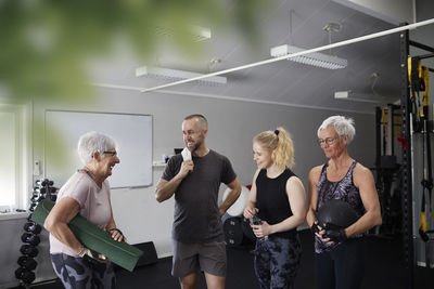 Happy people standing and talking in gym