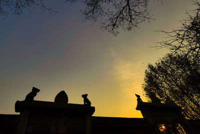 Low angle view of silhouette building against sky during sunset