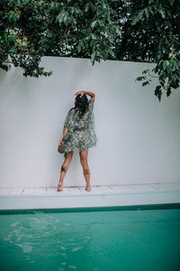 Rear view of woman standing in swimming pool