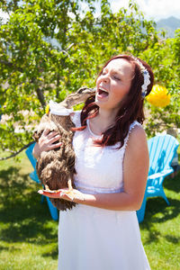 Woman wearing sunglasses standing against plants