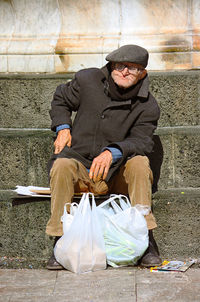 Midsection of man sitting outdoors