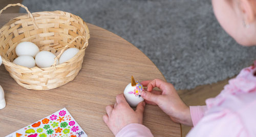 Cropped hand of woman holding food on table