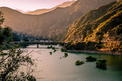 Scenic view of river and mountains against sky