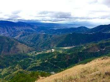 Scenic view of mountains against cloudy sky