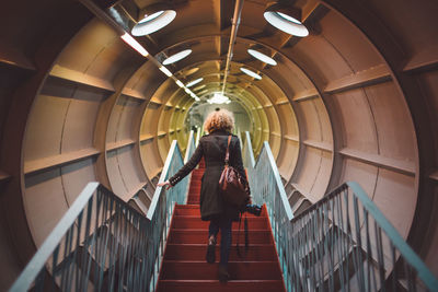 Rear view of woman standing on steps