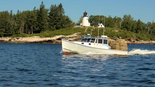 Boat sailing in sea against sky