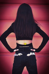 Rear view of woman standing against red background