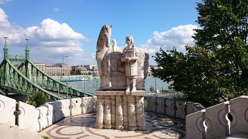 Statue of buildings against cloudy sky