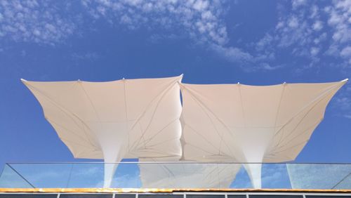 Low angle view of white umbrella against blue sky