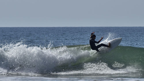 Man surfing in sea against clear sky