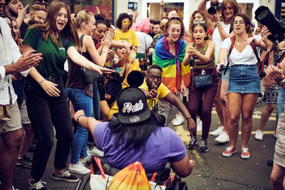 Group of people dancing on street in city