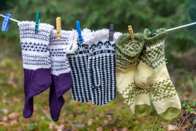 Photography with knitted gloves, gloves hanging on a rope, handicraft concept, knitting as a hobby