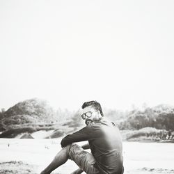 Portrait of man wearing sunglasses while sitting on field